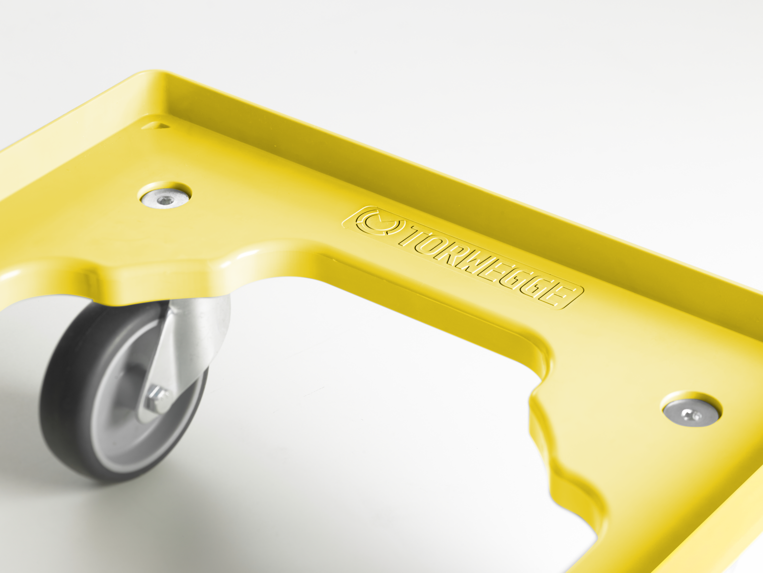 A bright yellow transport trolley component features a rounded edge and a significant cutout. A gray wheel with a metal casing is visible, supporting the structure over a plain background. The branding -TORWEGGE- is embossed on the surface.