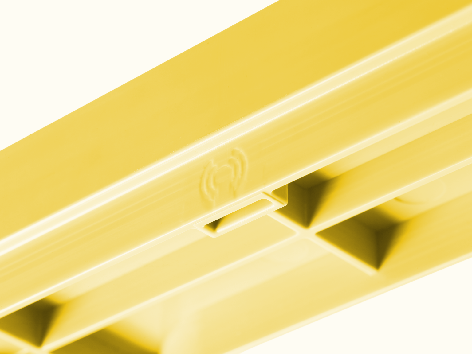 A yellow plastic component is shown, featuring an elongated shape with a smooth surface. It displays structural grooves and an inset area, likely for mounting or fitting purposes, against a light background.