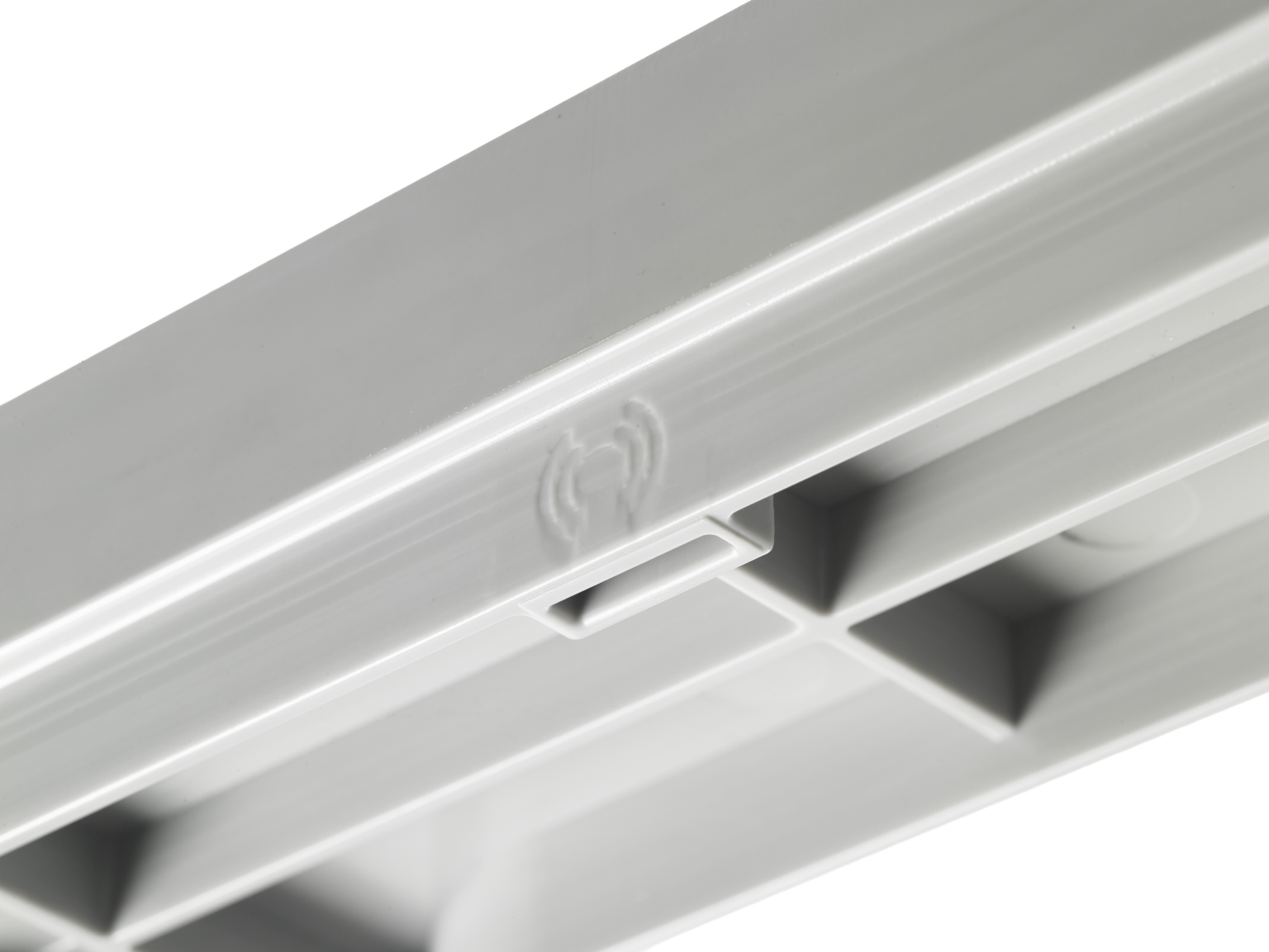 A light gray component features a rectangular shape with a smooth surface. It has a small slot and an embossed symbol on one side, likely indicating its connection or functionality. The background is blank.